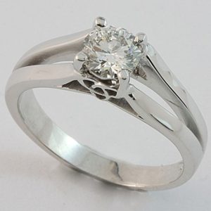 Solitaire diamond ring with split band and three-point Celtic knot detail under setting.